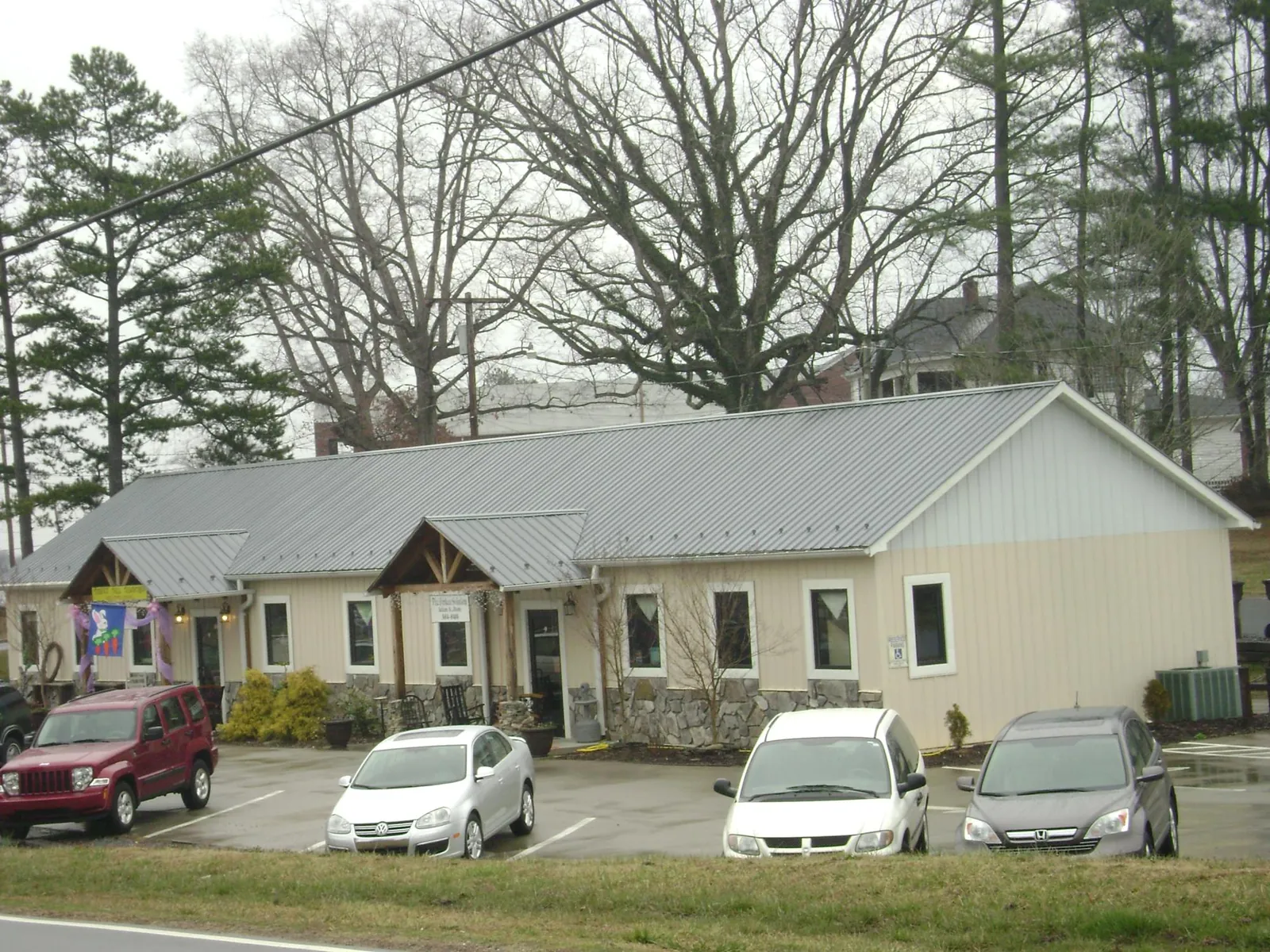 Gray metal roof with timber entry brackets on a small commercial building in Ortonville