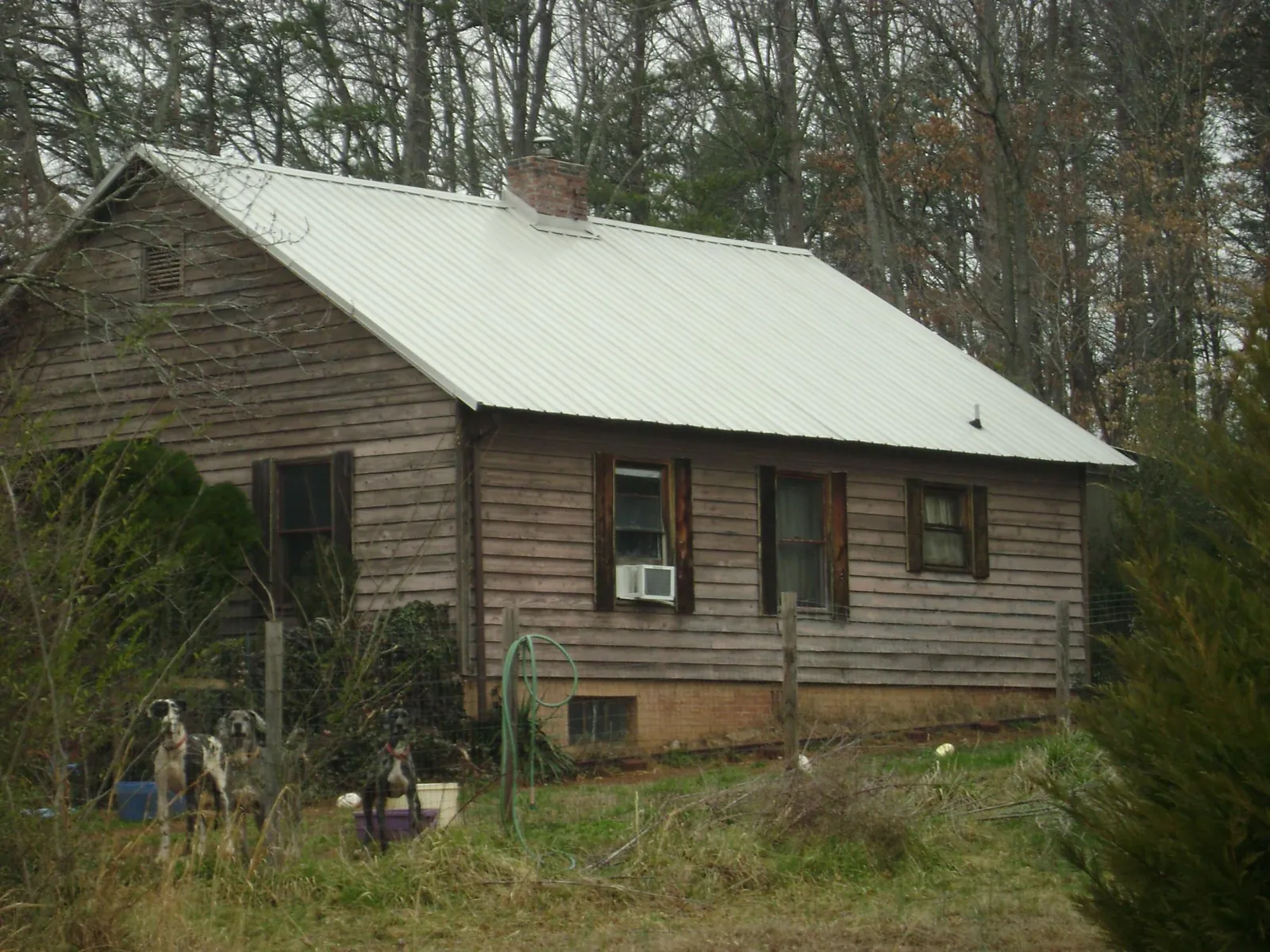 White metal roof on an old wood sided farmhouse, from a Metal Roof Installation job in Ortonville
